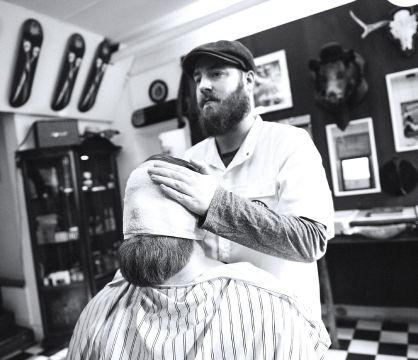 barber doing facials to a client